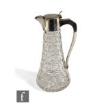 A hallmarked silver and clear cut glass claret jug, the tapering glass body rising to a silver