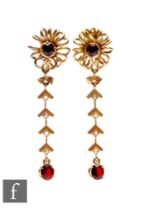 A pair of 9ct garnet and diamond drop earrings, central garnet within a coil design above four