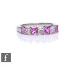 An 18ct hallmarked white gold pink sapphire and diamond seven stone ring, alternating square cut,