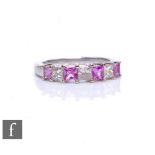 An 18ct hallmarked white gold pink sapphire and diamond seven stone ring, alternating square cut,