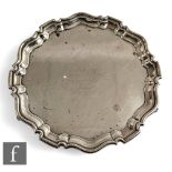 A hallmarked silver circular salver with central presentation engraving within stepped borders and