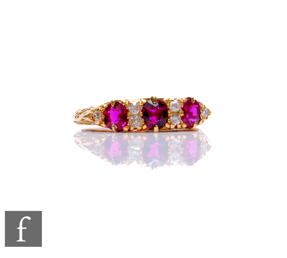 An early 20th Century 18ct hallmarked ruby and diamond seven stone ring, three rubies spaced by twin