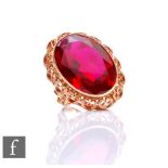 A 14ct single stone ring, paste red stone, length 25mm, collar set to a scroll border, weight 14.5g,