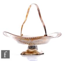 A hallmarked silver oval swing basket, shaped oval foot below foliate swag engraved and pierced