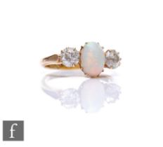 An 18ct opal and diamond three stone ring, central oval opal, length 9mm, flanked by a 0.40ct