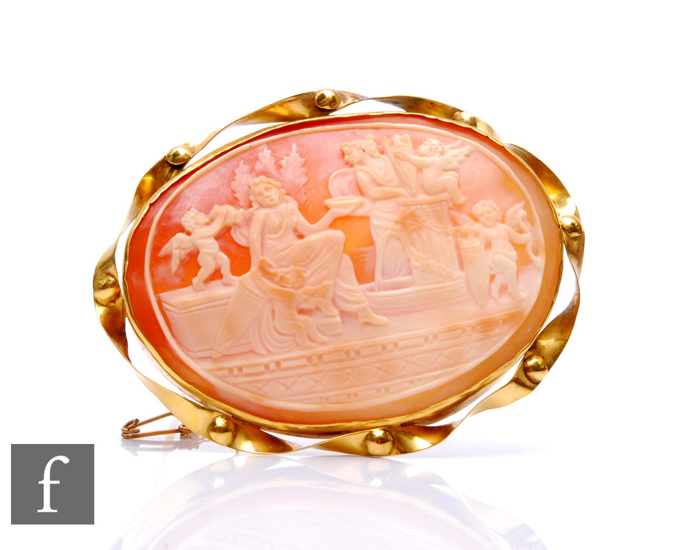 A 9ct hallmarked mounted oval cameo brooch depicting a classical scene with a woman and cherubs in