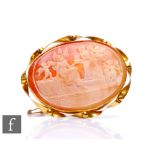 A 9ct hallmarked mounted oval cameo brooch depicting a classical scene with a woman and cherubs in
