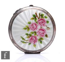 A hallmarked silver circular compact with enamelled pink roses to a white sunburst ground,