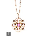 An Edwardian 9ct open work pendant set with central pink tourmaline and seed pearls, diameter