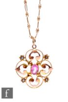 An Edwardian 9ct open work pendant set with central pink tourmaline and seed pearls, diameter