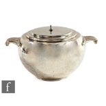 An Art Deco hallmarked silver bomb shaped twin handle sugar basin of plain form, lacking finial,