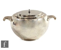 An Art Deco hallmarked silver bomb shaped twin handle sugar basin of plain form, lacking finial,