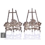 A pair of hallmarked silver menu holders modelled as easels with cherub and foliate scroll