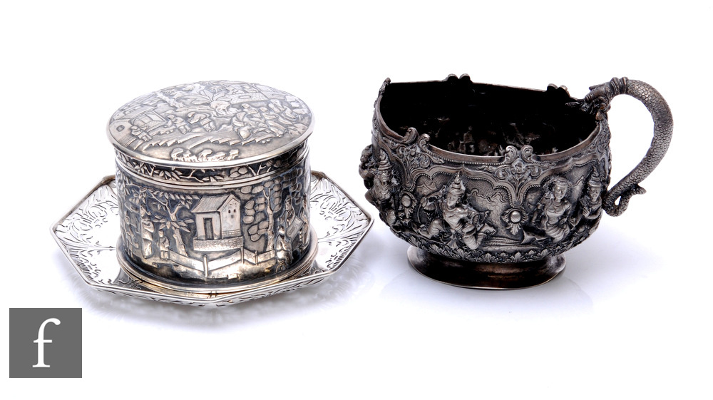 A Chinese silver circular box and cover decorated with figures in a landscape setting, height 8cm,