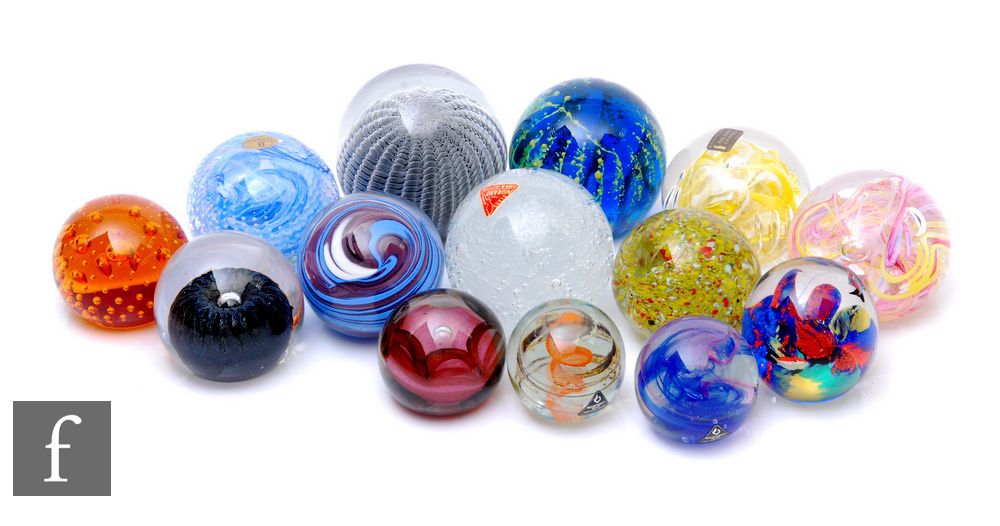 A collection of assorted glass paperweights, of varying forms and internal decorations, makers to