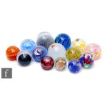 A collection of assorted glass paperweights, of varying forms and internal decorations, makers to