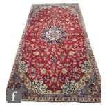 A Persian Isfahan rug, the red central ground with blue and ivory coloured floral ground,  354cm x