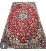 A Persian Isfahan rug, the red central ground with blue and ivory coloured floral ground,  354cm x