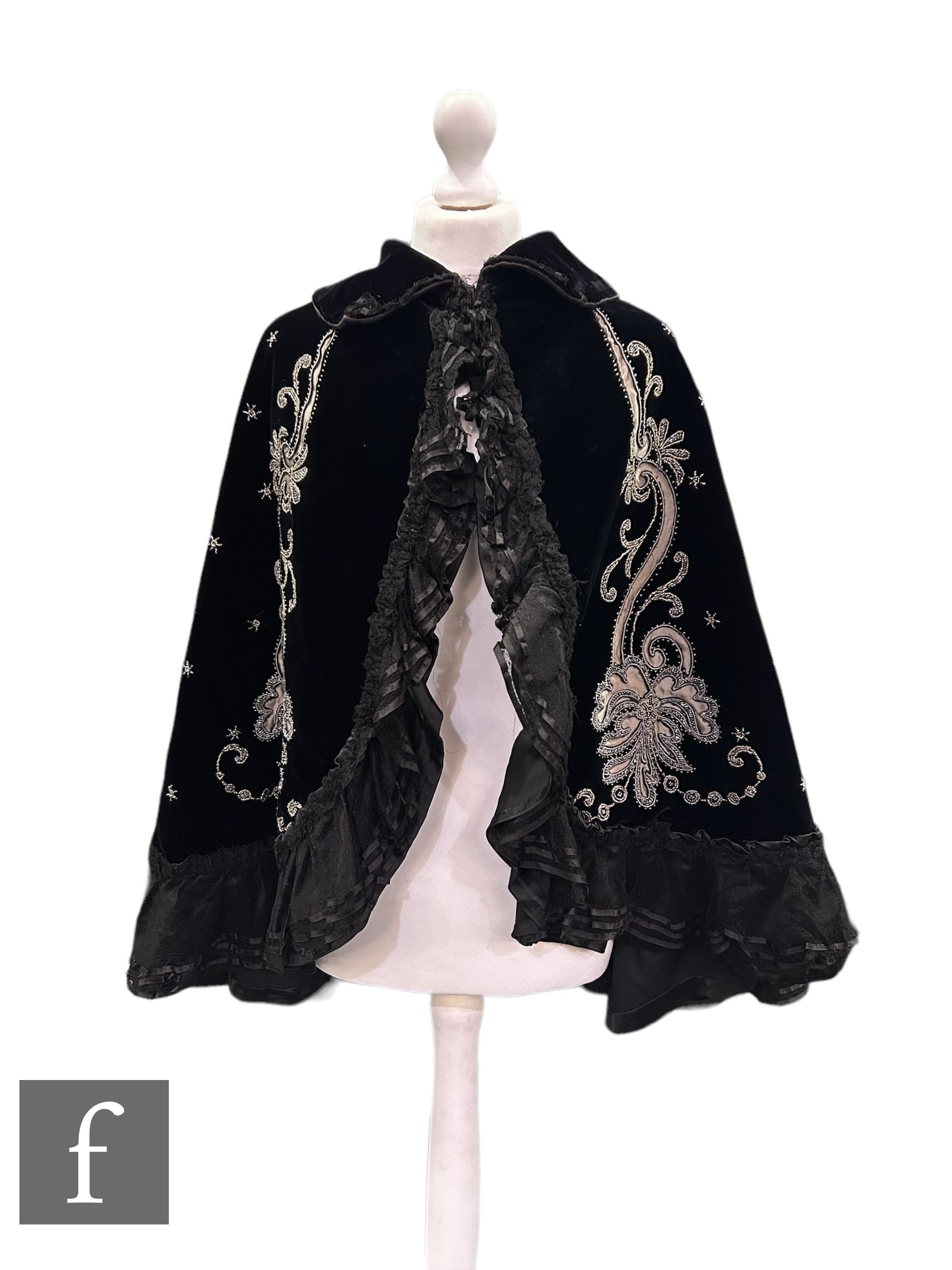 A late 19th Century black velvet evening cape, decorated with bead and grey silk foliate scroll