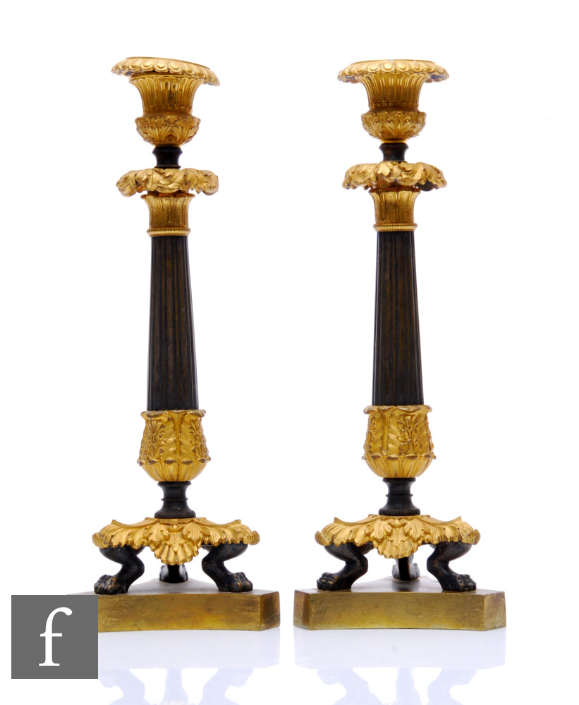A pair of late 19th Century French Empire style candlesticks, gilt acanthus leaf sconces on paw feet