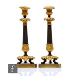 A pair of late 19th Century French Empire style candlesticks, gilt acanthus leaf sconces on paw feet