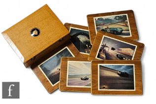 A 1950s Jaguar oak case mounted with a raised circular logo concealing a set of six table mats