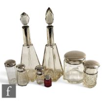 A collection of Victorian and later glass silver topped scent and dressing table jars, all of