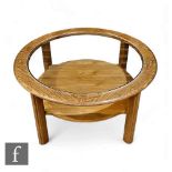 A G-Plan ash coffee table of circular from, raised on four block supports, the glass inset top above