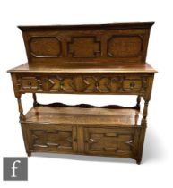 A late 1920s light oak two tier buffet in the 17th Century style, fitted with two geometric