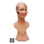 A 1930s shop display mannequin head, the painted plaster figure, modelled as a smiling young