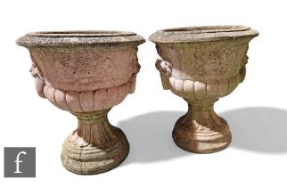 A large pair of reconstituted garden urns, each of pedestal campana form with lion mask ring