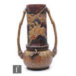 A large Bretby 'Japanese' vase, flanked by bamboo handles, relief moulded with depictions of