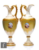 A matched pair of Coalport porcelain ewers, circa 1900, each of pedestal form with acanthus loop