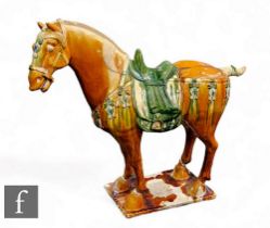 A Chinese Tang Dynasty style horse, of typical form, modelled in standing position with ochre and
