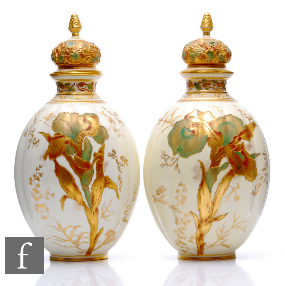 A pair of Derby porcelain vases of ovoid lobed form, surmounted by relief moulded gilt covers with