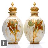 A pair of Derby porcelain vases of ovoid lobed form, surmounted by relief moulded gilt covers with