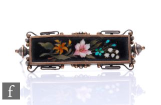 A Victorian Ashford marble brooch on a white metal mount, the rectangular plaque with inlaid lily