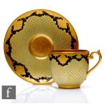 A Coalport 'Jewelled' porcelain cup and saucer, richly decorated with a cobalt blue ground with