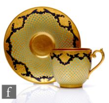 A Coalport 'Jewelled' porcelain cup and saucer, richly decorated with a cobalt blue ground with