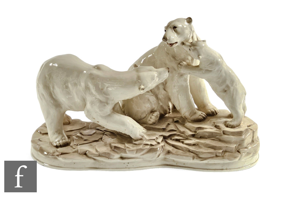 A contemporary pottery polar bear family group, modelled on an icy outcrop, with all over white