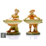 A pair of Royal Worcester table ornaments, circa 1907, modelled as male and female figures holding