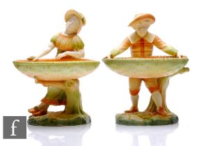 A pair of Royal Worcester table ornaments, circa 1907, modelled as male and female figures holding