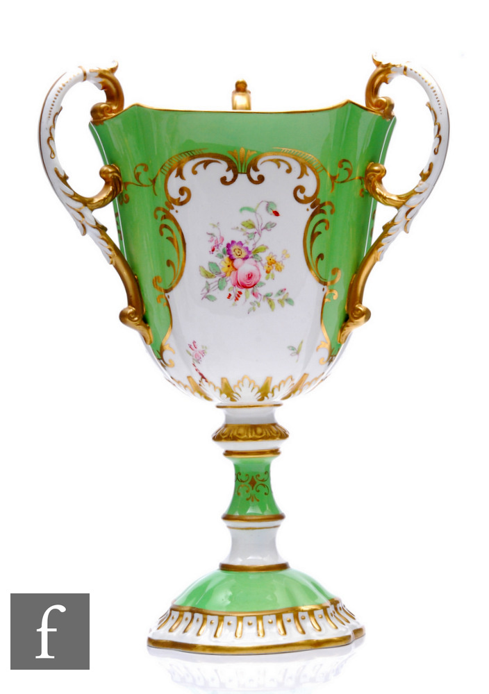 A Coalport porcelain, pedestal three-handled cup, rising from a scalloped foot and applied with