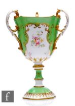 A Coalport porcelain, pedestal three-handled cup, rising from a scalloped foot and applied with