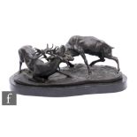 A late 20th Century bronze group of two rutting stags, after P J Mene, on oval base, stamped,