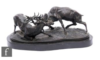 A late 20th Century bronze group of two rutting stags, after P J Mene, on oval base, stamped,