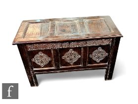 An 18th Century carved oak triple panel coffer raised on stile below a lunette carved frieze and