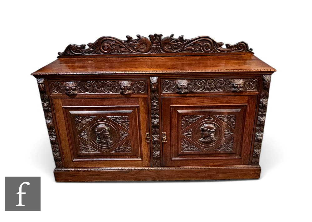 A Victorian carved oak sideboard fitted with two drawers over a panelled cupboard plinth base,