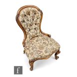 A Victorian nursing chair, the mahogany spoon back frame raised on scrolling supports, with floral