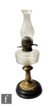 A late 19th Century oil lamp, the clear turned black marble base with brass stem and clear crystal